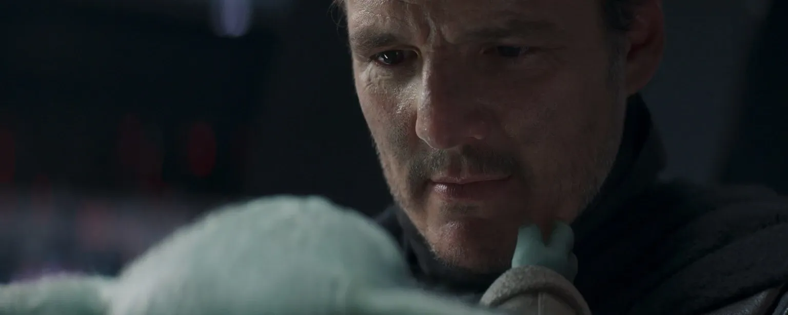 Din Djarin retire son masque et montre son vrai visage à Grogu.